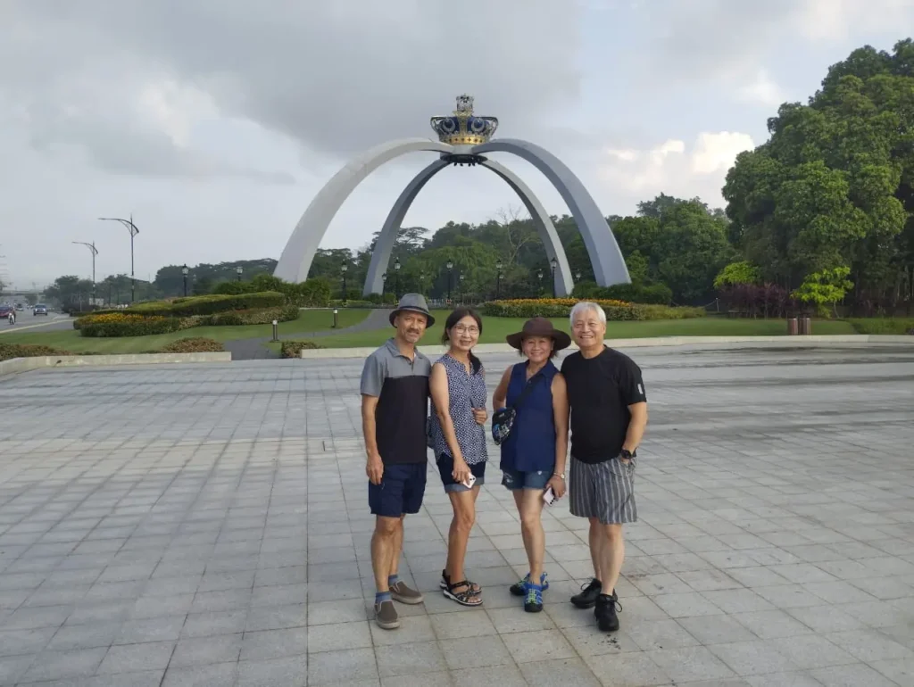 Previous Johor Bahru tour guests at the crown arch near Istana Bukit Serene