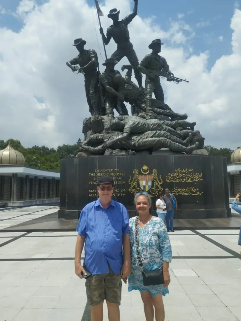 Previous Kuala Lumpur tour guests in front of the National Monument of Malaysia