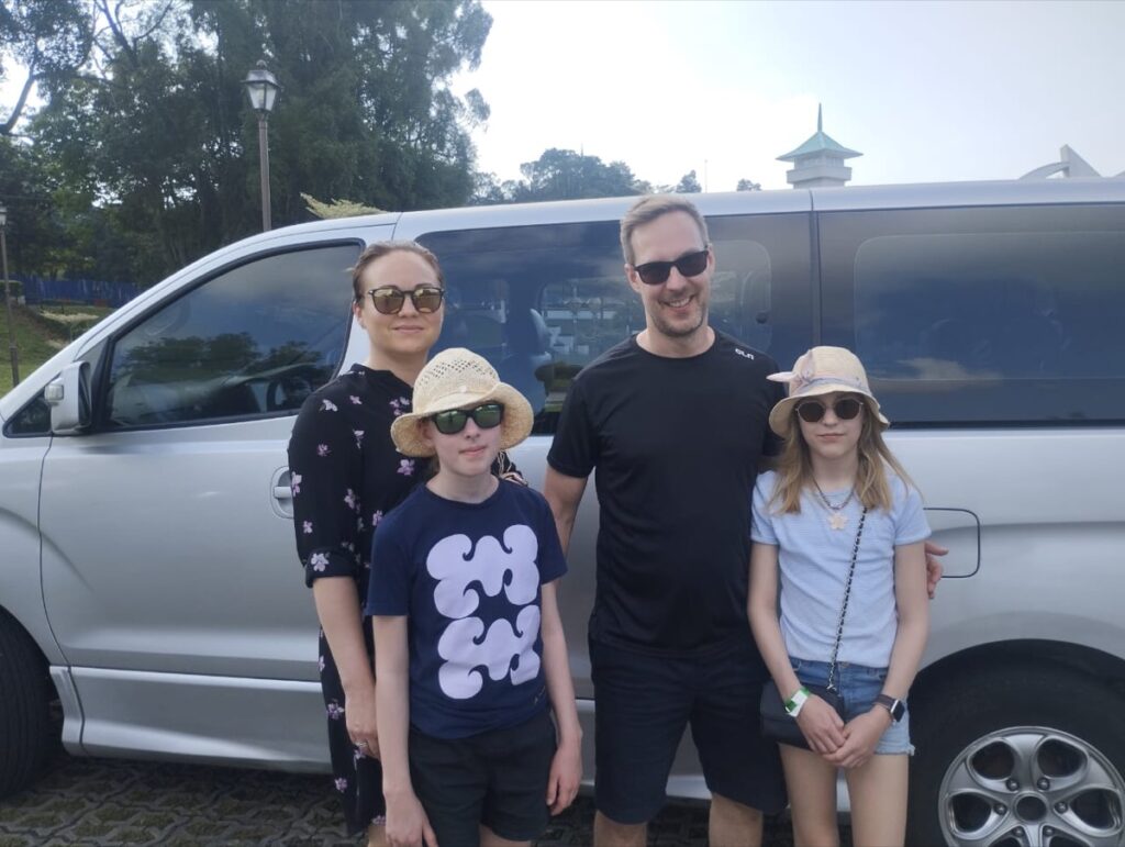 Family group beside an example vehicle used on a previous private day trip
